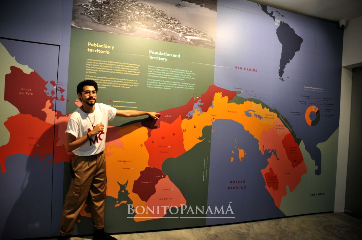 Der Mann zeigt auf eine bunte Panama-Karte an der Wand, auf der Regionen, Städte, Gewässer und Informationen auf Spanisch und Englisch verzeichnet sind.