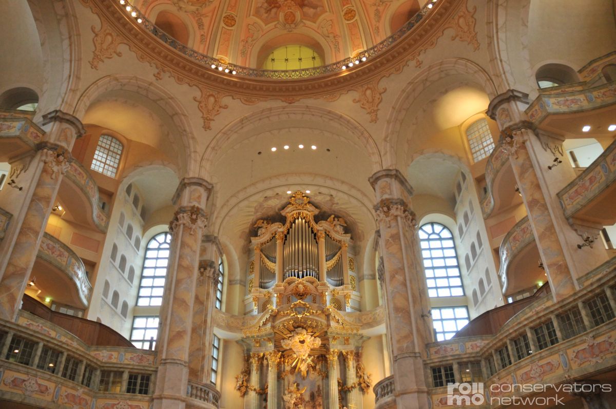 Frauenkirche in Dresden, mit hohen Fensterbögen, verzierten Säulen und goldgeschmückter Orgel unter einer Kuppel.
